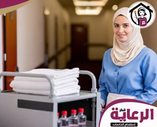 نموذج طلب استقدام وزارة العمل قطر 30699789 الرعاية عاملة خدمة في الفندق تقف مبتسمة، تحمل عربة المناشف لتوفير أفضل خدمة للنزلاء في الممرات.